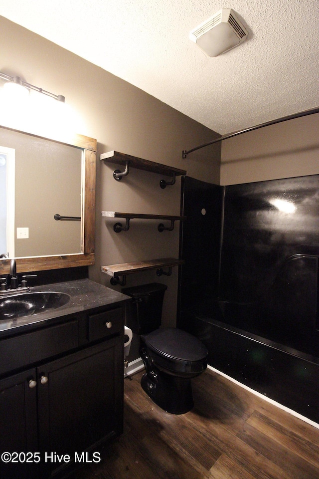 full bathroom with visible vents, wood finished floors, vanity, toilet, and  shower combination
