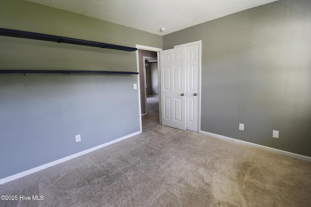 unfurnished bedroom featuring baseboards, a textured ceiling, carpet, and a closet