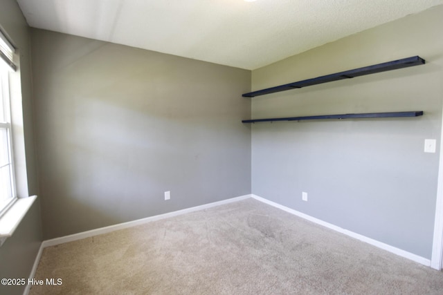 carpeted empty room with baseboards