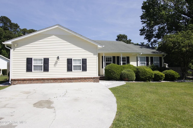 ranch-style home with a front yard and concrete driveway