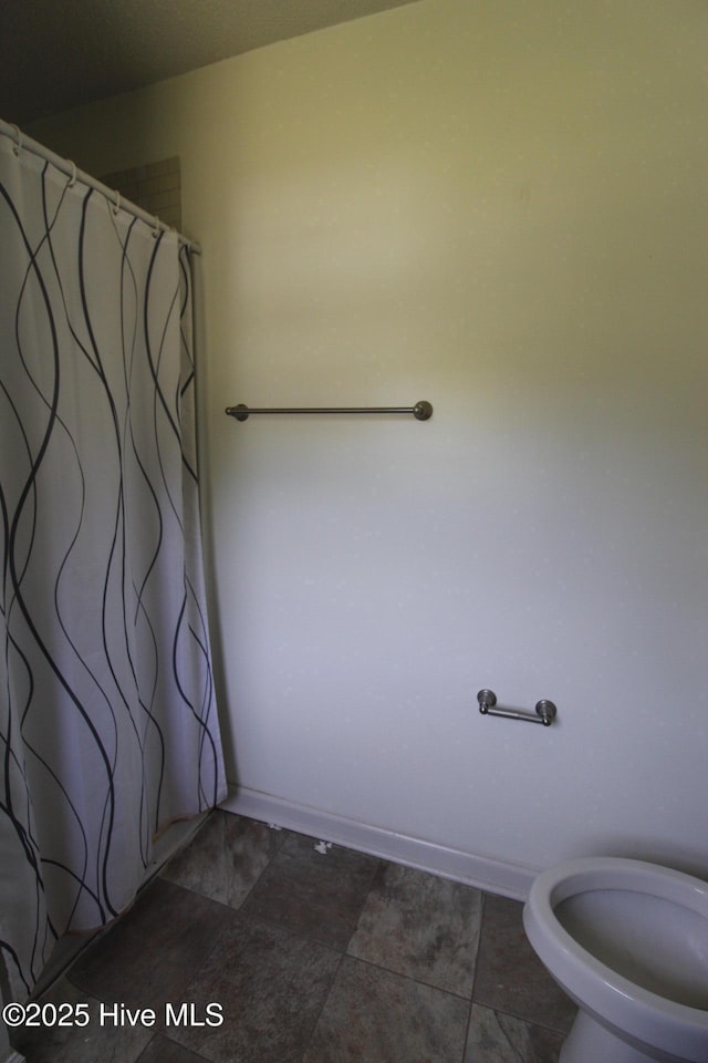 full bath featuring toilet and a shower with shower curtain