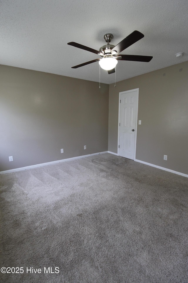 unfurnished room with baseboards, carpet, a ceiling fan, and a textured ceiling