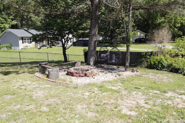 view of yard featuring an outdoor fire pit and fence