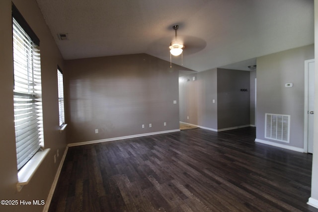 spare room featuring a ceiling fan, baseboards, visible vents, and wood finished floors