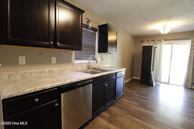 kitchen with a sink, a textured ceiling, baseboards, dark wood-type flooring, and stainless steel dishwasher