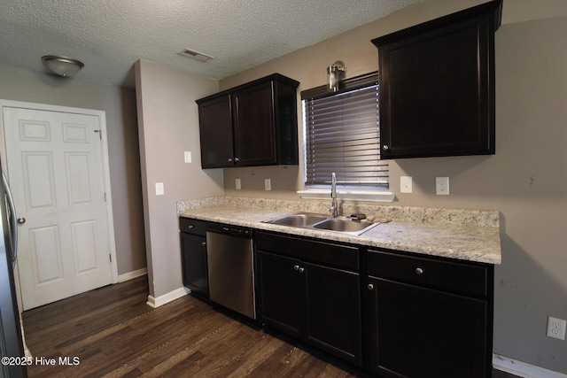 kitchen with dark wood-style flooring, visible vents, dishwasher, a sink, and light countertops