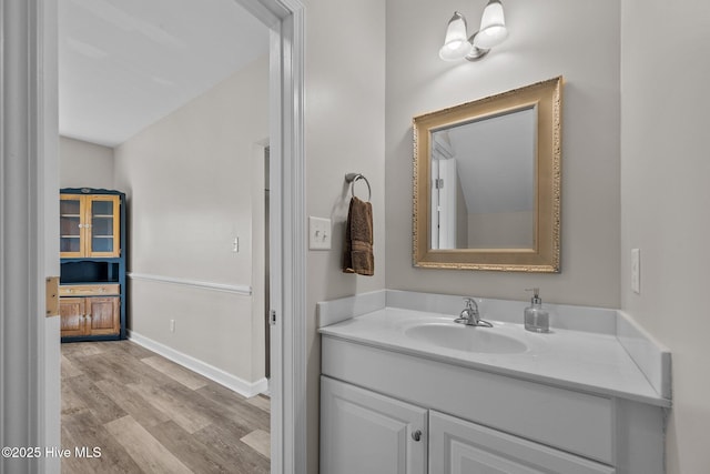 bathroom with vanity, baseboards, and wood finished floors