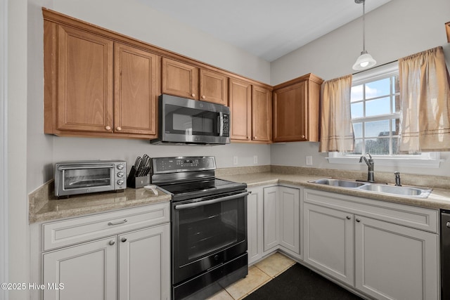 kitchen featuring a toaster, light countertops, stainless steel microwave, black range with electric stovetop, and a sink