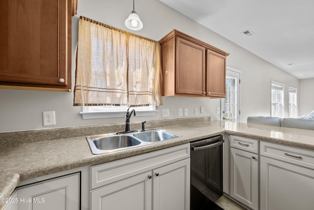 kitchen with dishwashing machine, light countertops, brown cabinets, and a sink