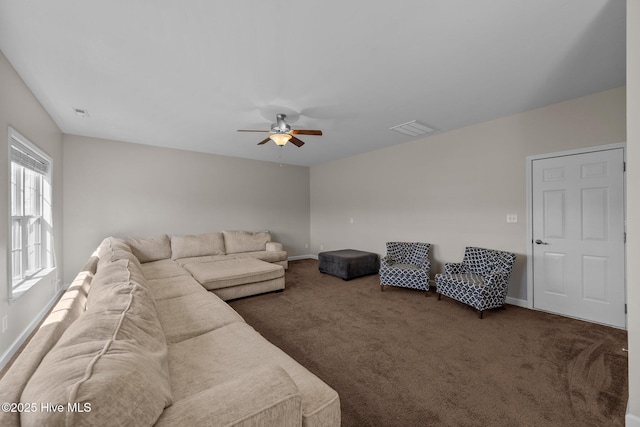 living area featuring visible vents, carpet flooring, baseboards, and ceiling fan