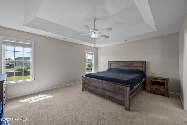 bedroom featuring baseboards, a tray ceiling, and carpet flooring