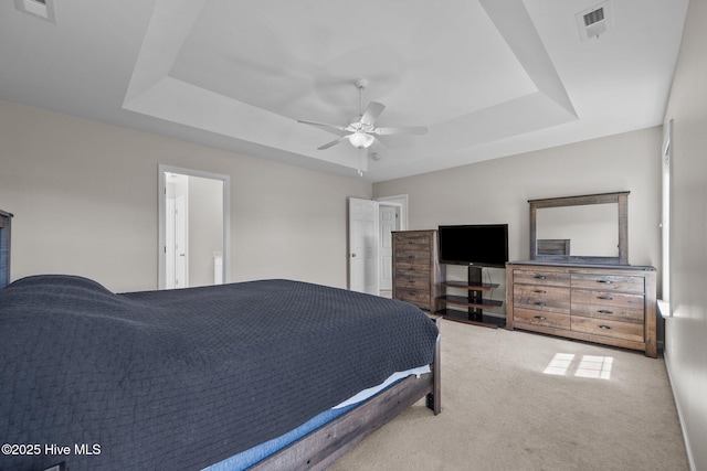 bedroom featuring a raised ceiling, ceiling fan, carpet flooring, and visible vents
