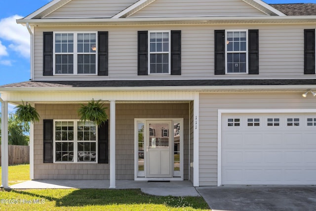 traditional-style home featuring fence, covered porch, and a shingled roof
