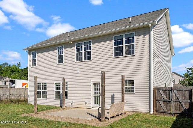 back of property featuring a lawn, a patio, and fence