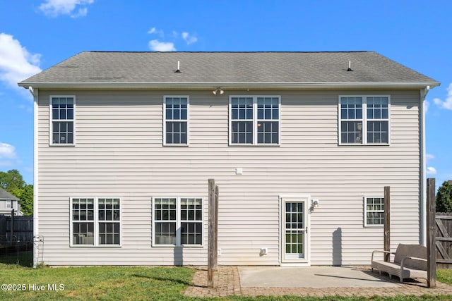 rear view of property with a lawn, a patio, and fence