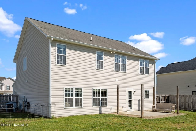 rear view of property with a lawn, a patio area, and fence