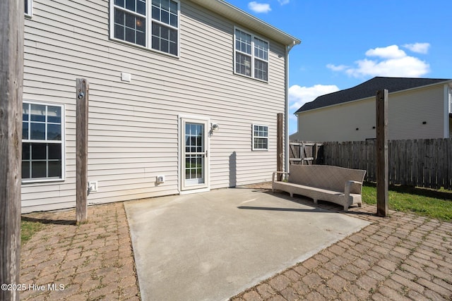rear view of house featuring fence and a patio area