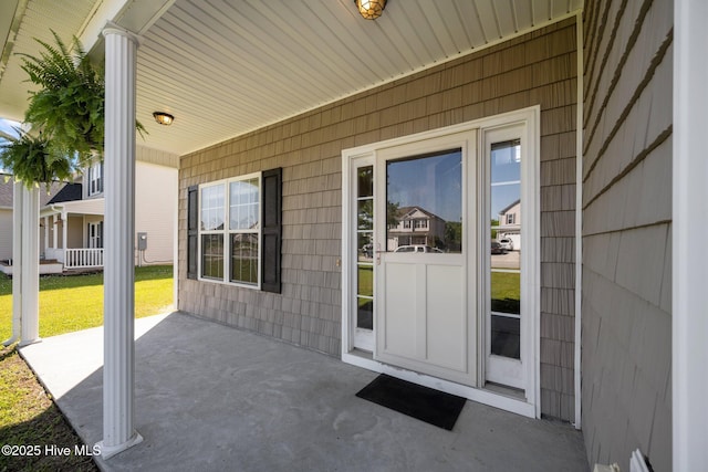 doorway to property with a porch and a yard