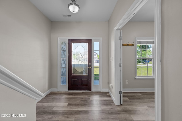 entryway with baseboards, visible vents, and wood finished floors