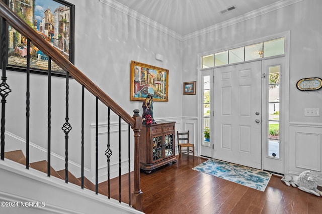 foyer entrance with stairs, visible vents, ornamental molding, and a decorative wall
