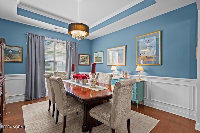 dining room with visible vents, ornamental molding, a raised ceiling, and dark wood-type flooring