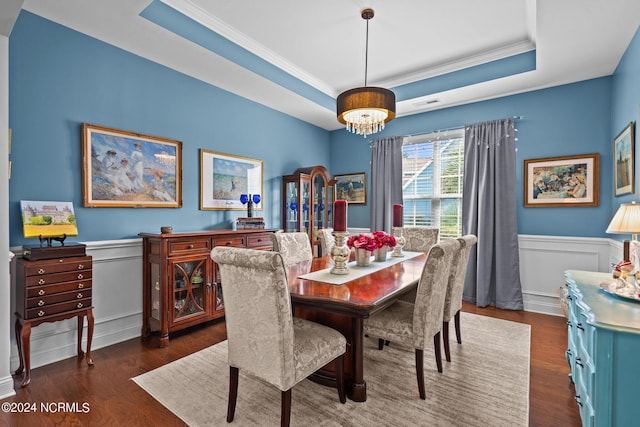 909 Tidalwalk Dr, Wilmington, NC 28409 - dining area featuring a tray ceiling, crown molding, wood finished floors, wainscoting, and a chandelier