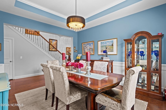 dining space with ornamental molding, wood finished floors, stairway, a wainscoted wall, and a chandelier
