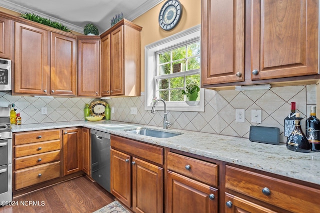 kitchen with dark wood-style flooring, light stone countertops, a sink, stainless steel appliances, and backsplash