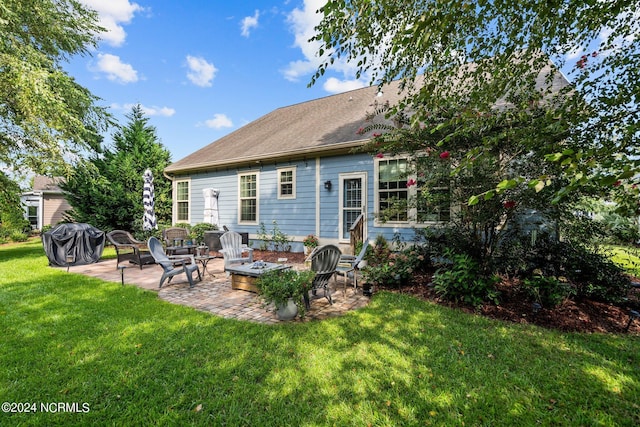 back of house with a patio, an outdoor fire pit, a lawn, and roof with shingles