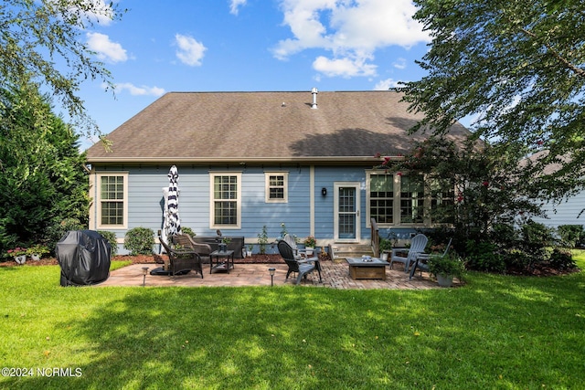 rear view of property featuring a shingled roof, a fire pit, a patio area, and a yard