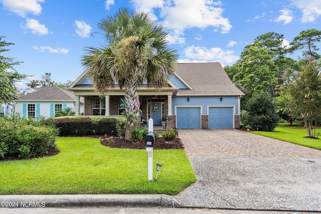 craftsman inspired home with brick siding, decorative driveway, a garage, and a front yard