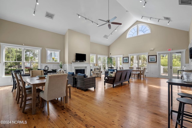dining room with ceiling fan, visible vents, a fireplace, light wood-type flooring, and track lighting