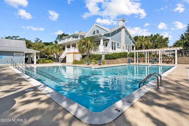 pool featuring fence and a pergola