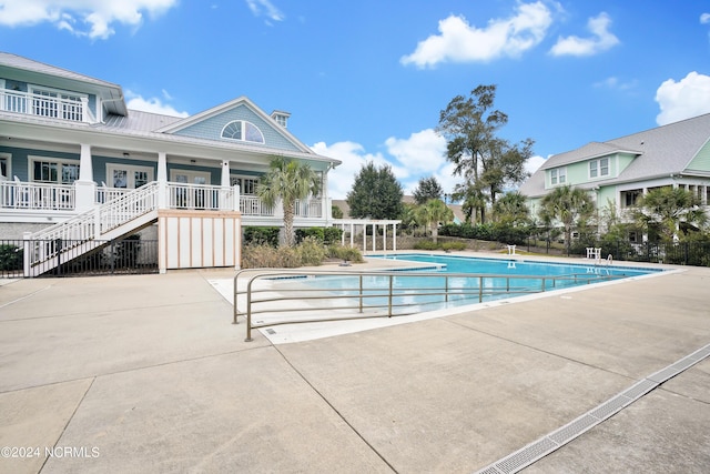 pool featuring a patio, fence, and stairway
