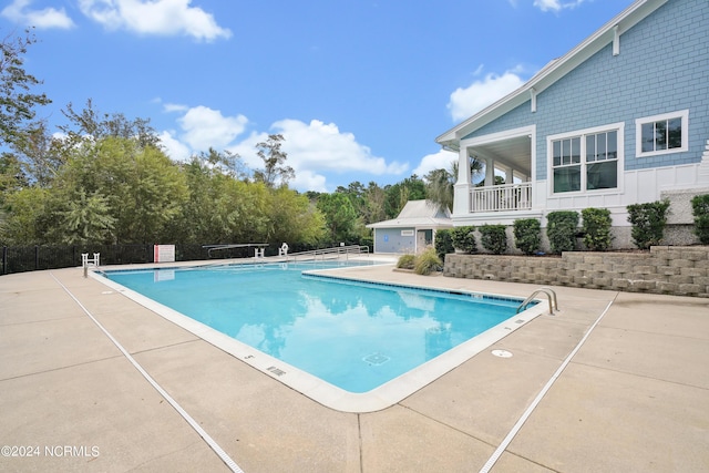 pool featuring fence and a patio