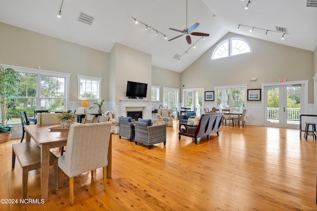 living room with high vaulted ceiling, ceiling fan, rail lighting, and visible vents