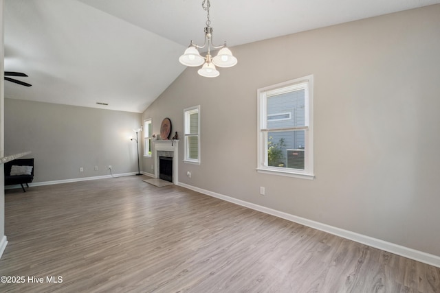 2686 Idlebrook Cir, Midway Park, NC 28544 - unfurnished living room with a chandelier, a fireplace, wood finished floors, baseboards, and lofted ceiling