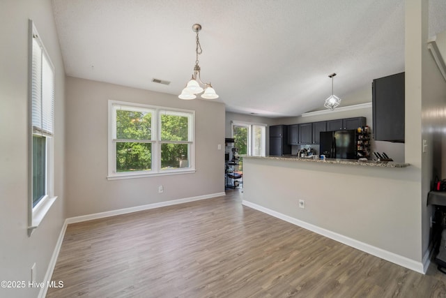 2686 Idlebrook Cir, Midway Park, NC 28544 - kitchen featuring freestanding refrigerator, light wood-type flooring, lofted ceiling, and a chandelier