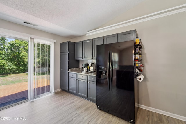 2686 Idlebrook Cir, Midway Park, NC 28544 - kitchen with black fridge, baseboards, a textured ceiling, light wood-style floors, and light stone counters