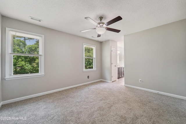 2686 Idlebrook Cir, Midway Park, NC 28544 - empty room featuring healthy amount of natural light, a textured ceiling, light carpet, a ceiling fan, and baseboards