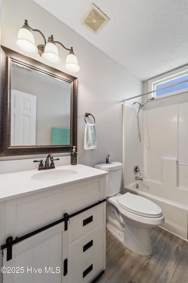 2686 Idlebrook Cir, Midway Park, NC 28544 - bathroom featuring wood finished floors, vanity, bathing tub / shower combination, toilet, and a textured ceiling