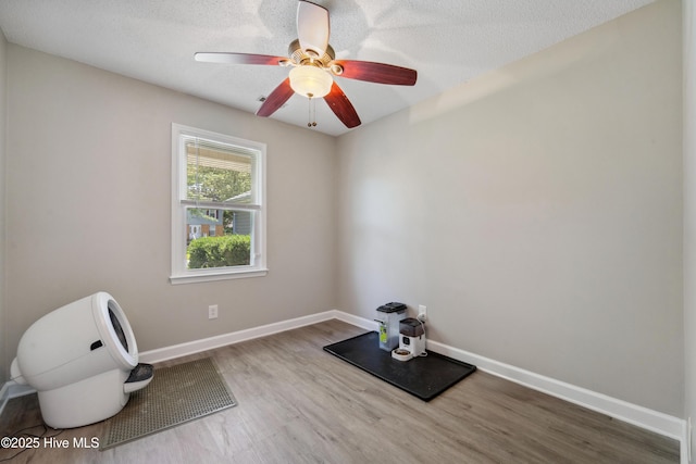 2686 Idlebrook Cir, Midway Park, NC 28544 - exercise area with wood finished floors, baseboards, ceiling fan, and a textured ceiling