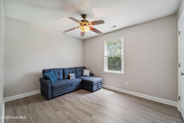 2686 Idlebrook Cir, Midway Park, NC 28544 - living area featuring wood finished floors, ceiling fan, baseboards, and a textured ceiling