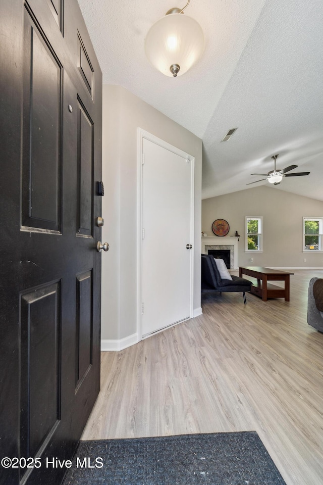 2686 Idlebrook Cir, Midway Park, NC 28544 - foyer entrance featuring light wood-style floors, lofted ceiling, a fireplace, a ceiling fan, and baseboards