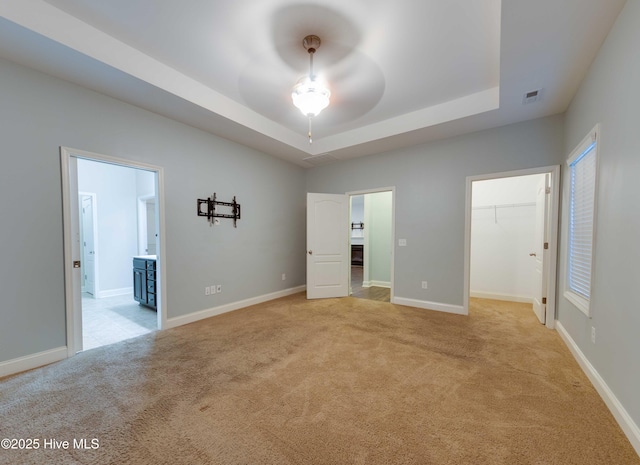 5225 National Garden Trl, Winnabow, NC 28479 - unfurnished bedroom with light colored carpet, ensuite bath, baseboards, a tray ceiling, and visible vents