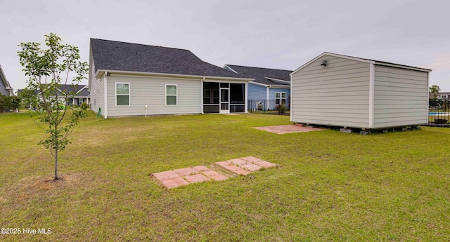 5225 National Garden Trl, Winnabow, NC 28479 - back of house with a storage unit, a shingled roof, a sunroom, an outdoor structure, and a yard