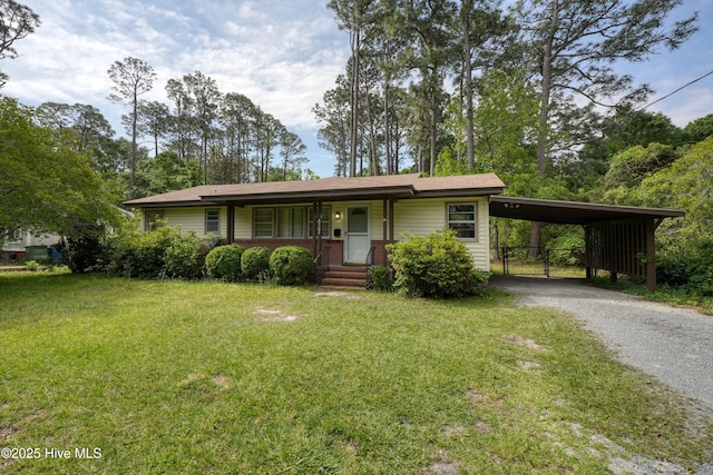 single story home featuring a carport, gravel driveway, and a front yard