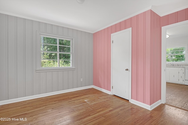 unfurnished bedroom featuring baseboards, ornamental molding, wood finished floors, and visible vents