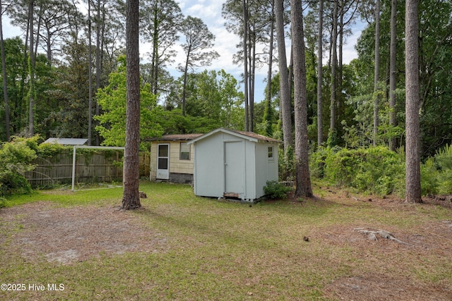 view of yard with a shed, an outbuilding, and fence