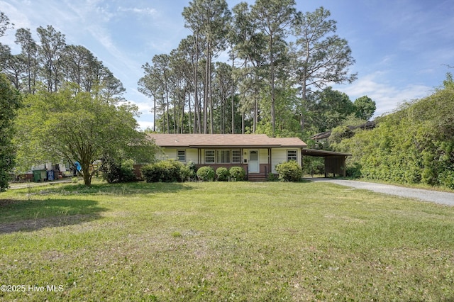 ranch-style home with an attached carport, driveway, and a front yard